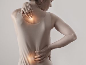 Woman experiencing back pain, possibly sore after physiotherapy treatment."